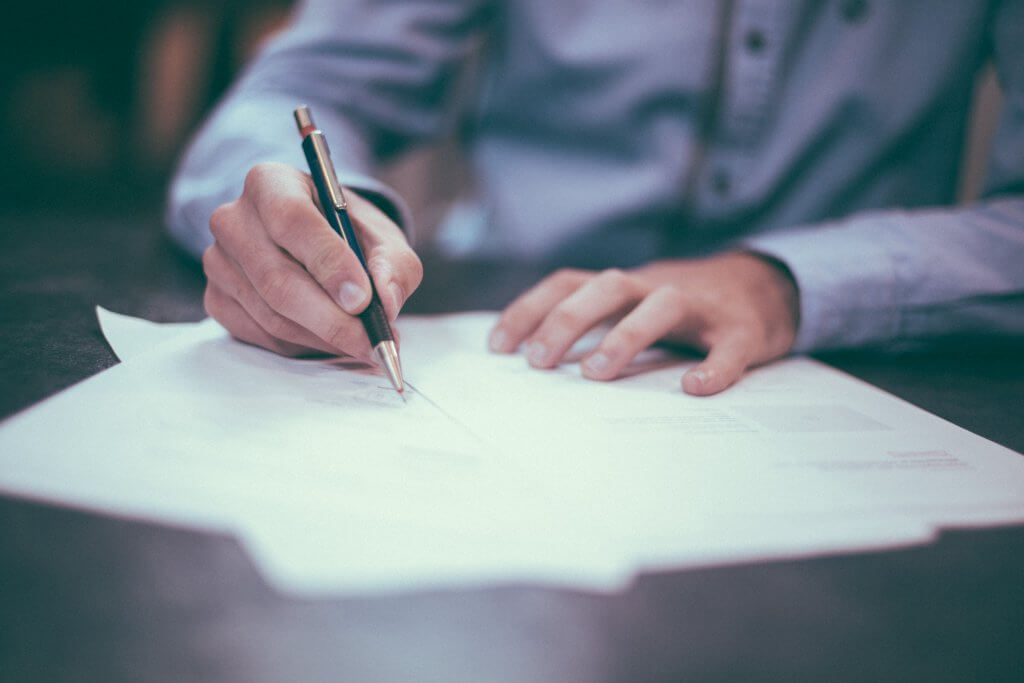 Image of a person signing a contract